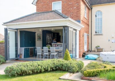 Four-leaf Origin bifold set with traffic door open on an Essex split-level extension