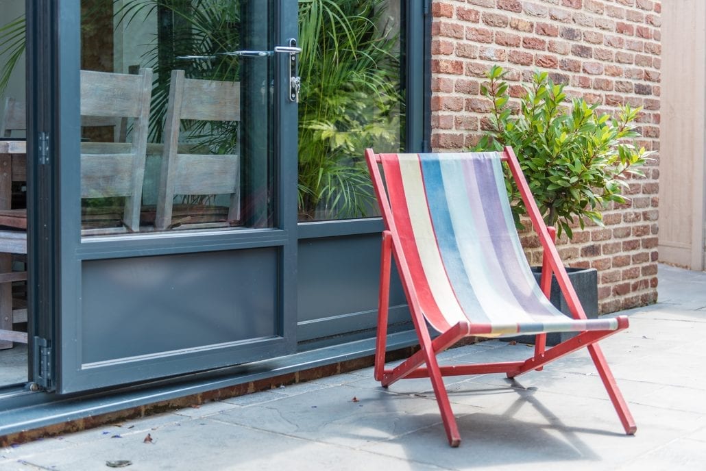Exterior view of bifold doors with solid lower sections and mullioned glazing