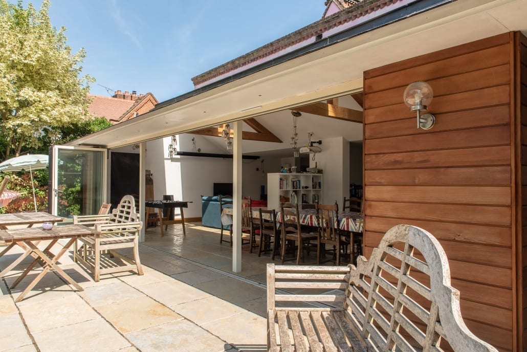 Seven-leaf bifold doors folded back to reveal full garden aperture