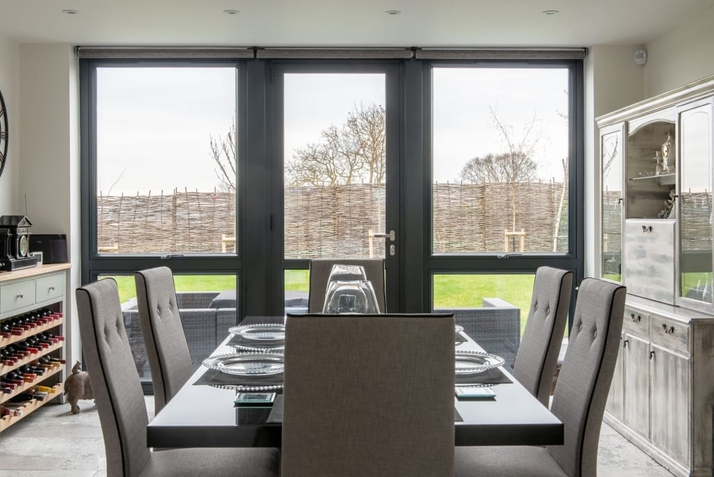 Origin aluminium bifold doors open to garden, Hall of Light new-build