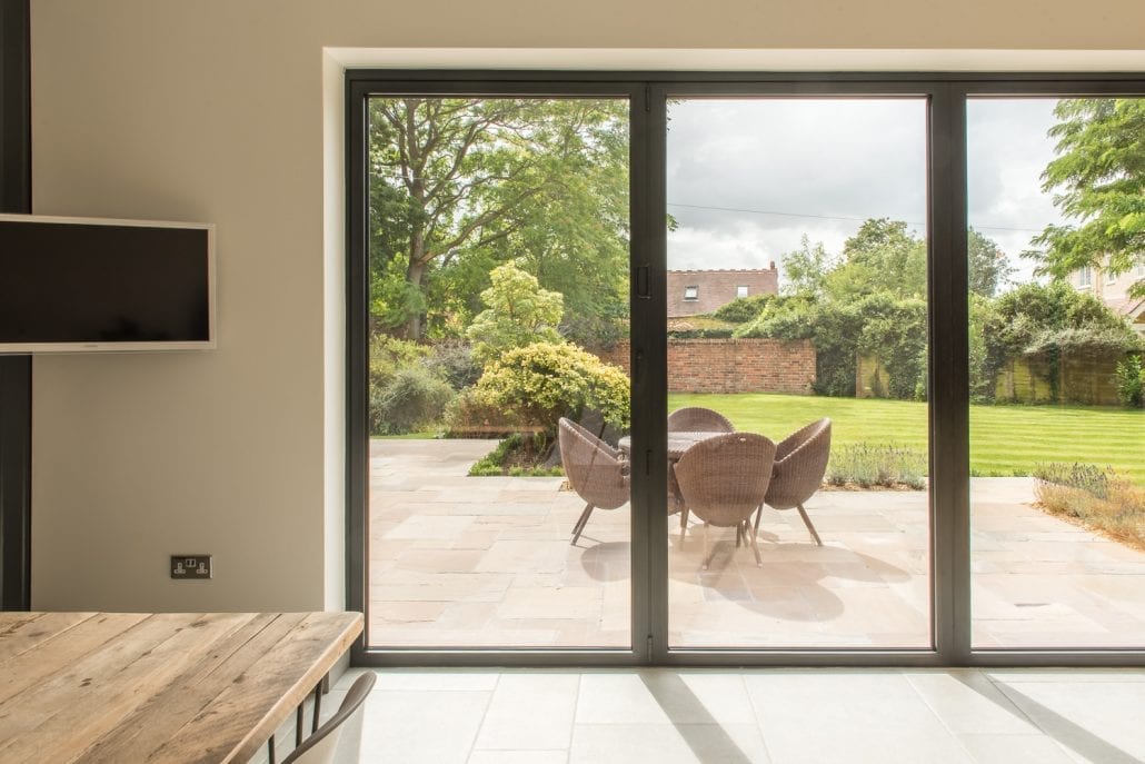 Black powder-coated aluminium bifolds on the ground floor rear extension adding modern contrast to old stock bricks