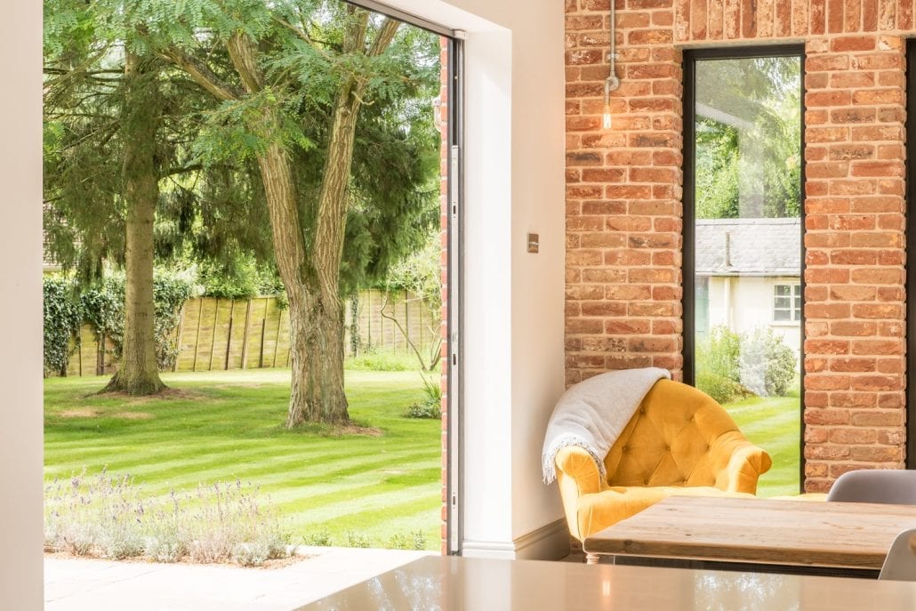 Rear elevation overview of the two-storey extension with bifold doors and triptych windows