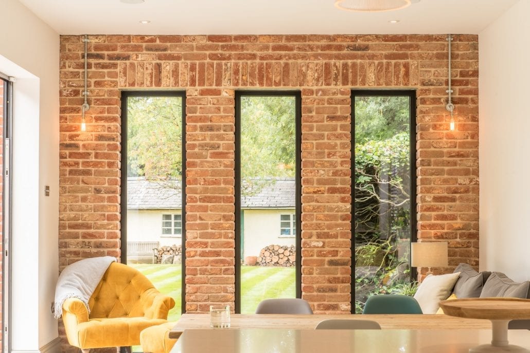 Rear elevation with large-span black aluminium bifold doors blending interior and exterior spaces