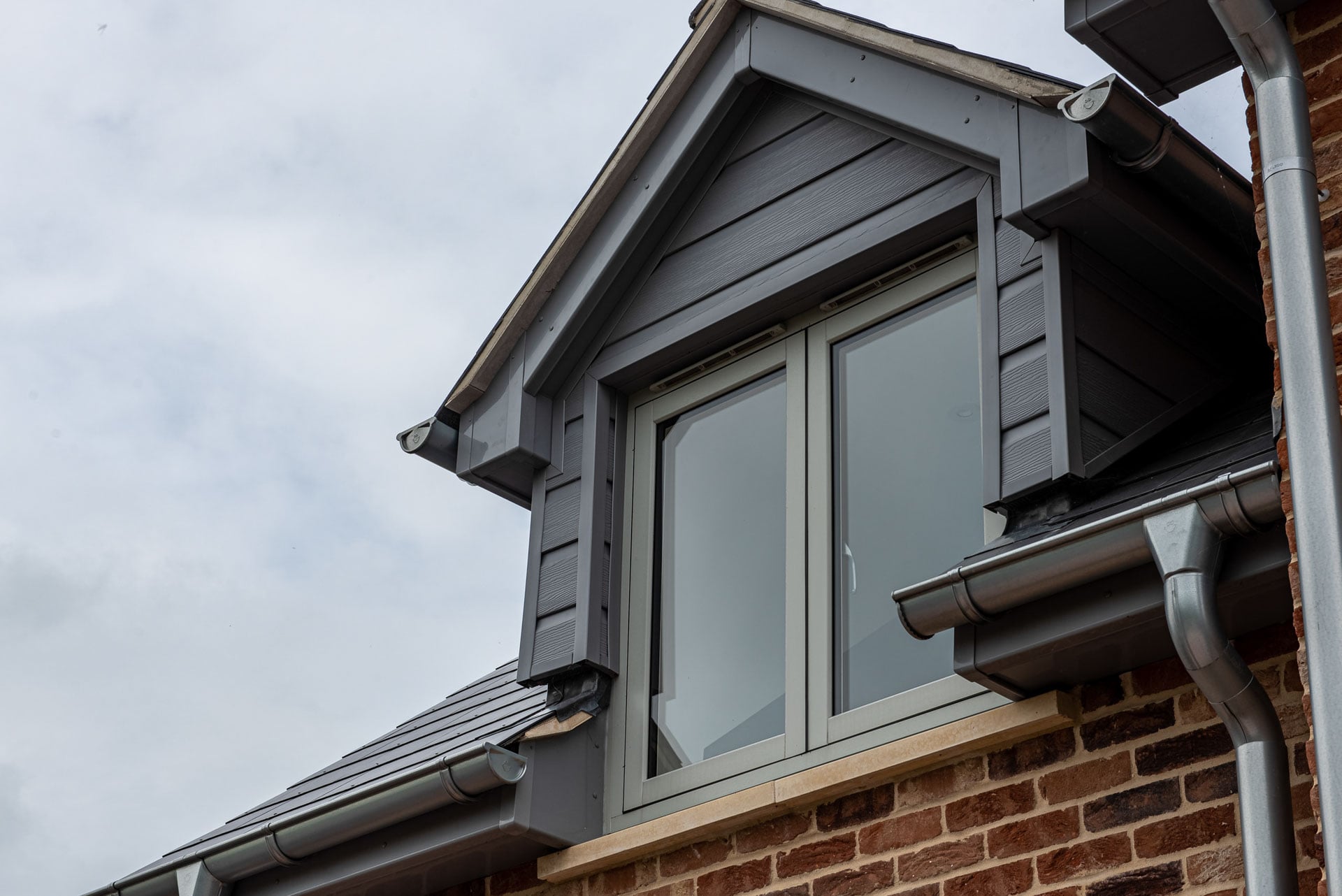 Anthracite casement window with shutters in brick gable, Essex