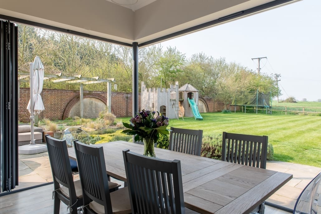 Continuous open corner created by offset Origin bifold doors on kitchen extension