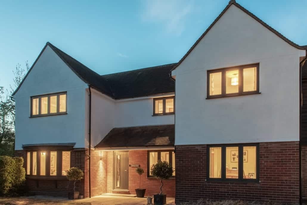 Home at dusk with lit flush casement windows, Windows Etc Essex