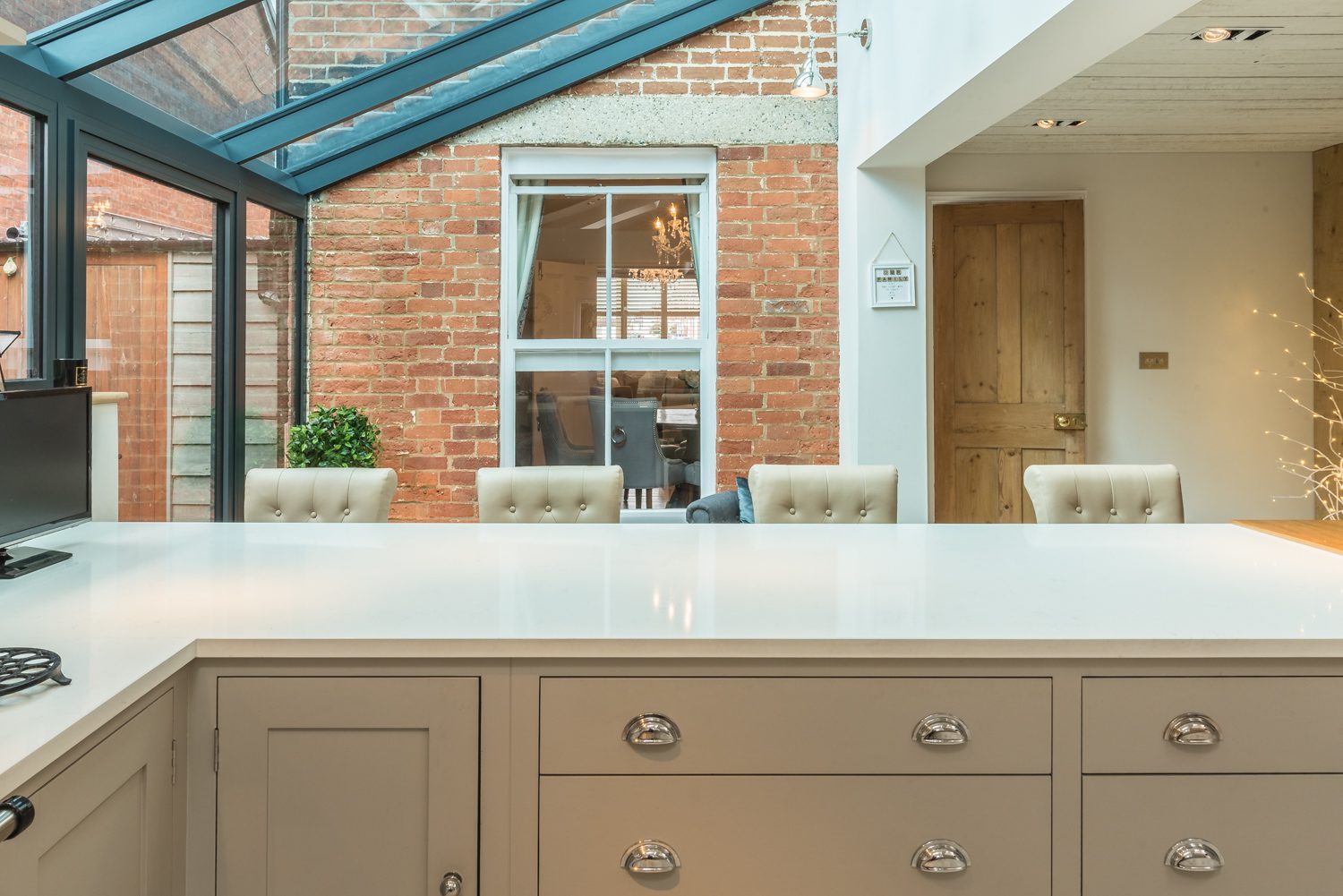 Wide door with upright glazing either side, lean-to extension