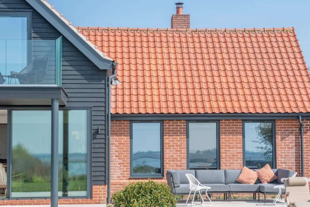 Origin aluminium windows on the Suffolk vernacular soft red brick and flint facade
