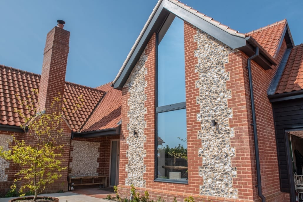 Origin aluminium windows in a brick and flint gable