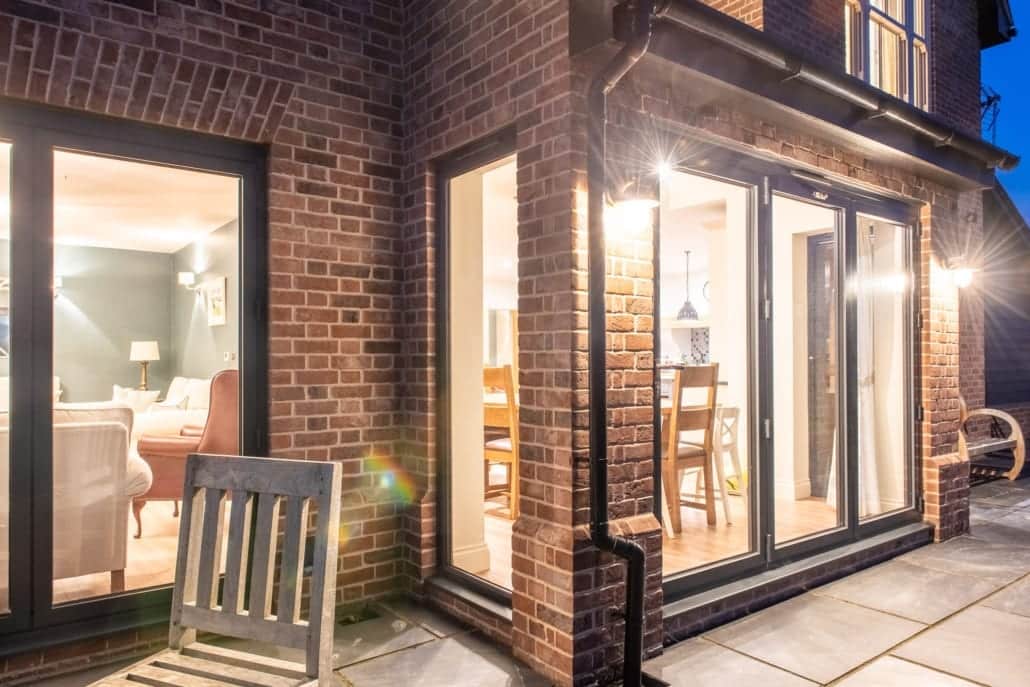 Black powder-coated Smarts bifold doors alongside feather-edge weatherboard cladding