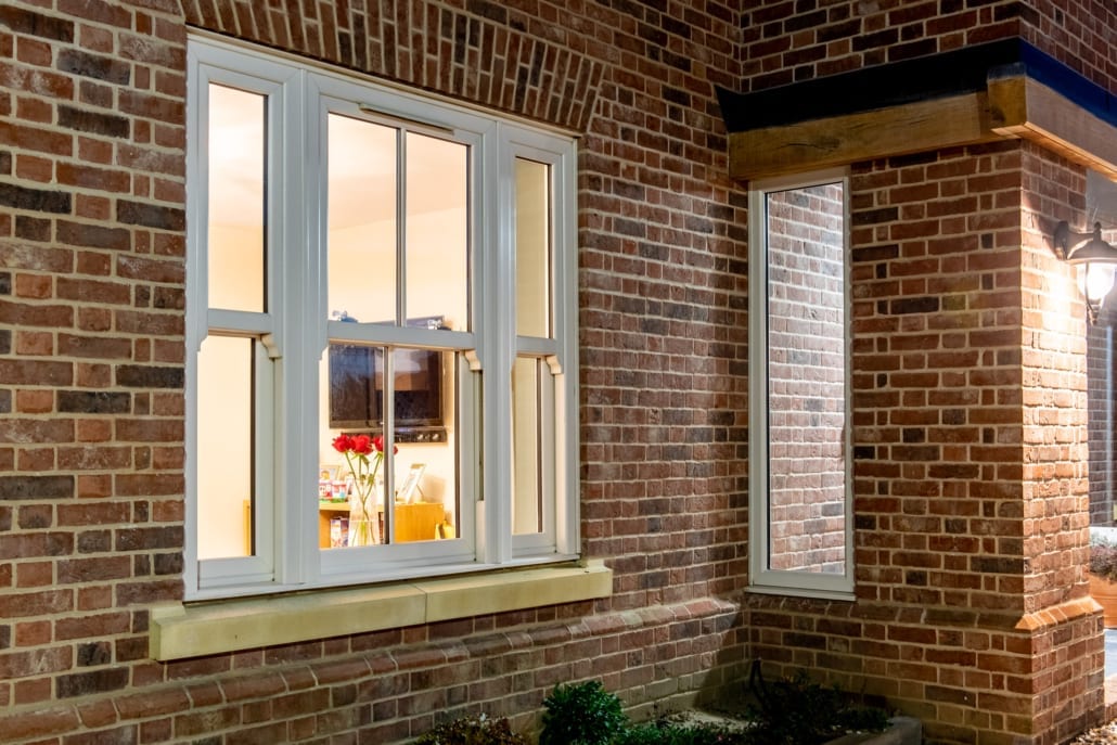 Exterior view of North Essex farmhouse showing cream sash windows and black bifold doors