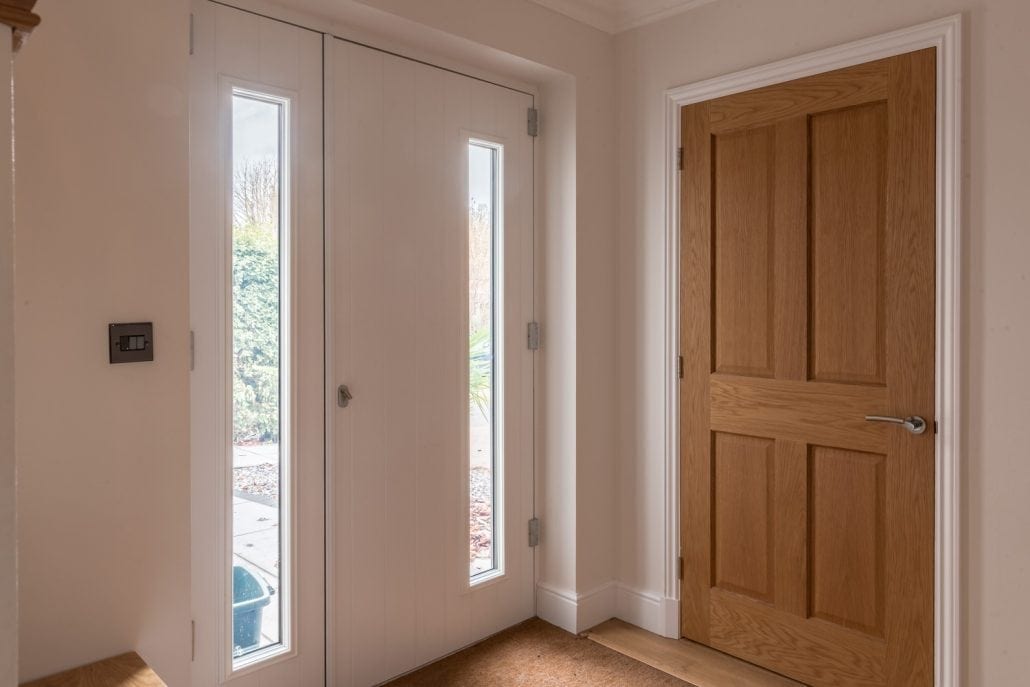 Full-width glazed sliding doors in open position on family home extension