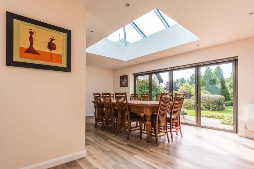 Dark grey Smarts aluminium bifold doors open to English country garden