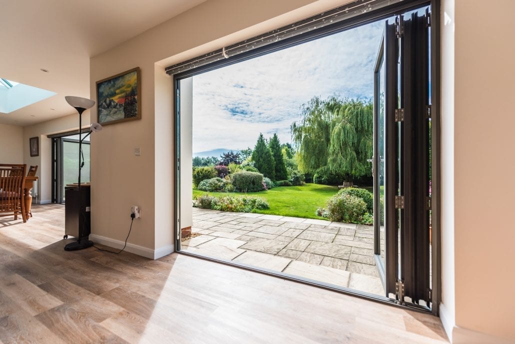 Interior entertainment room with Smarts bifolds and roof lantern in Essex