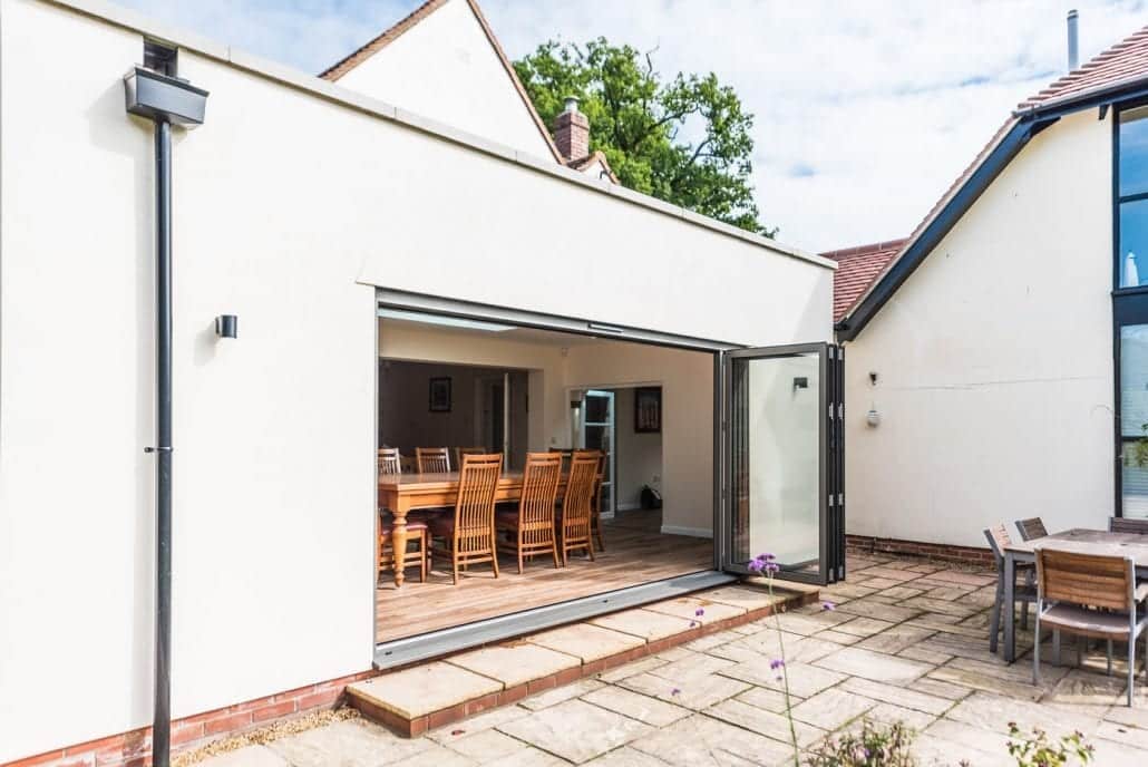 Smarts dark grey bifold doors framing Constablesque Essex countryside views