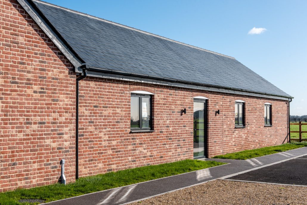 Tall picture windows without glazing bars on a rural Essex commercial barn conversion