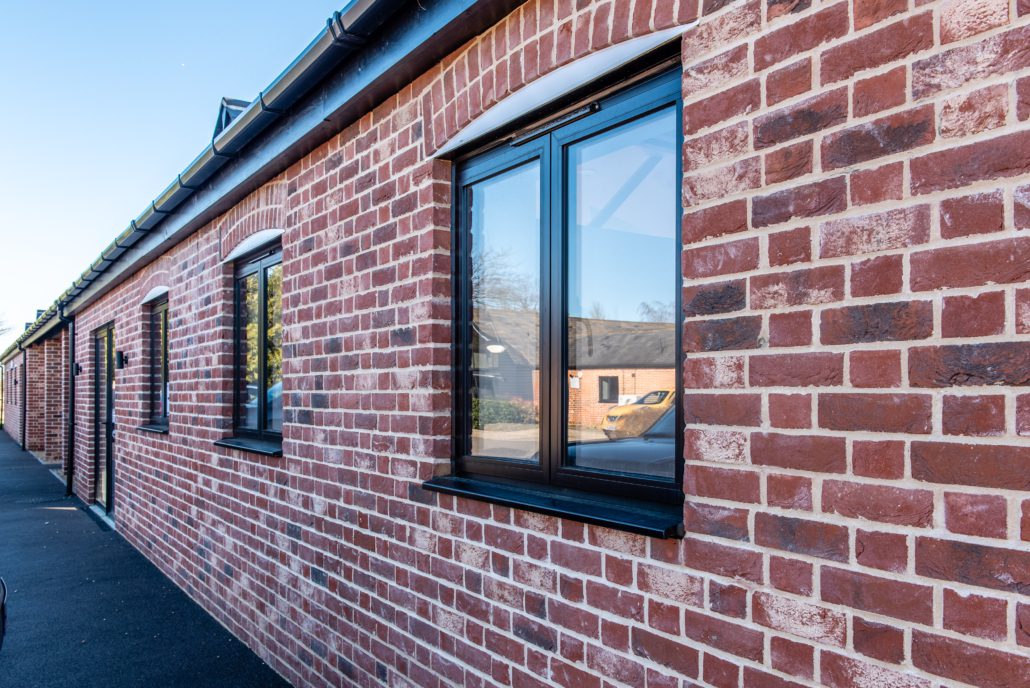 Black aluminium casement windows with black furniture on a barn conversion