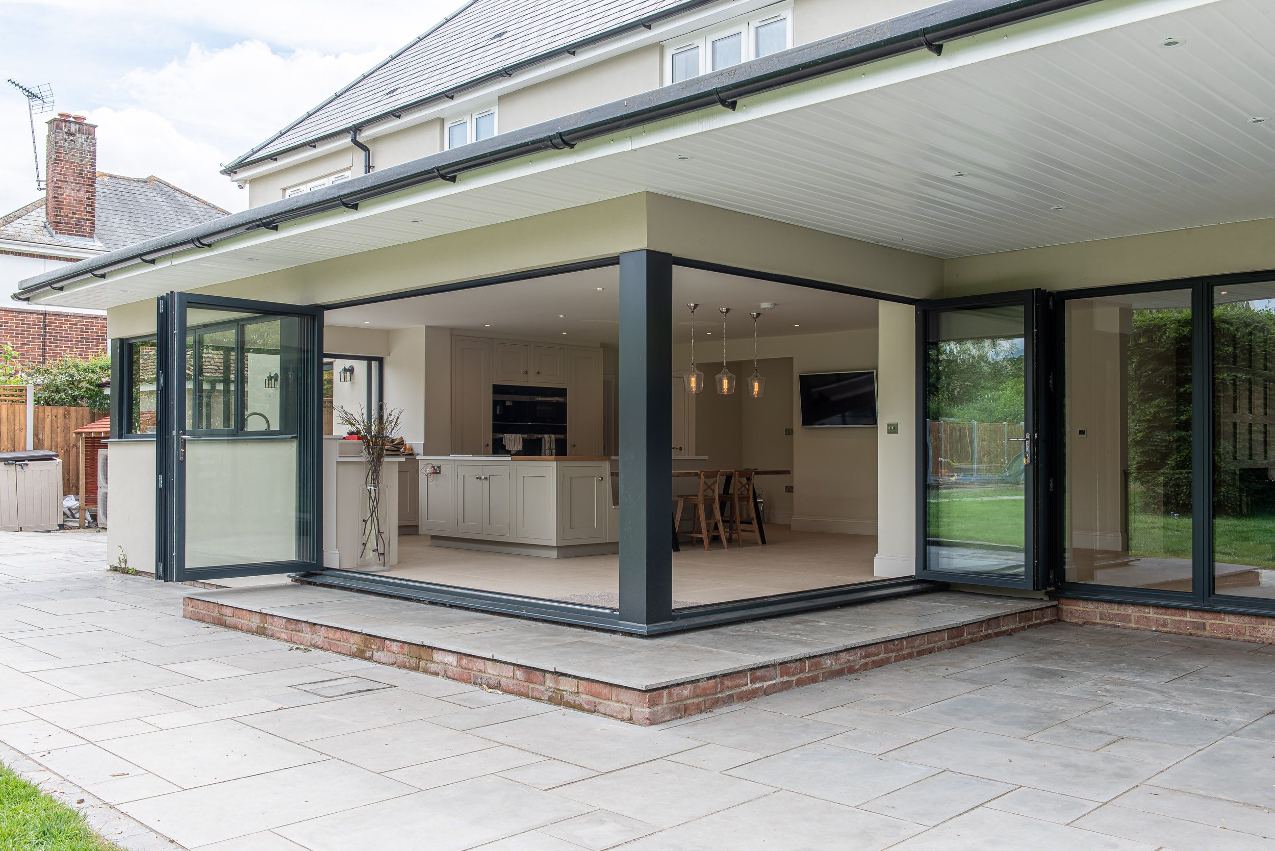 Open-plan living area with floor-to-ceiling glazing and Smarts bifold doors opening to the garden