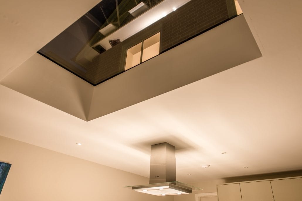 Night exterior showing bifold doors and garden seating area