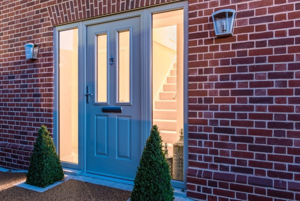 Aluminium bifold doors open to garden at dusk, Essex village property