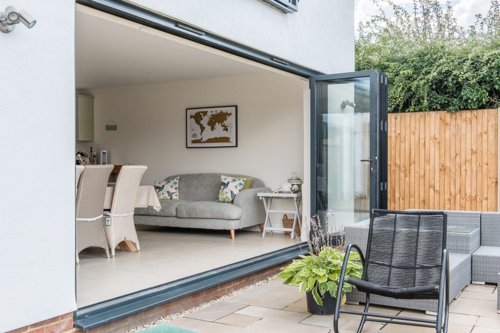 Open bi-folding doors connecting living space to garden, daytime