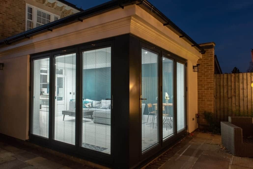 Bifold doors open to the garden at night, Colchester orangery remodel