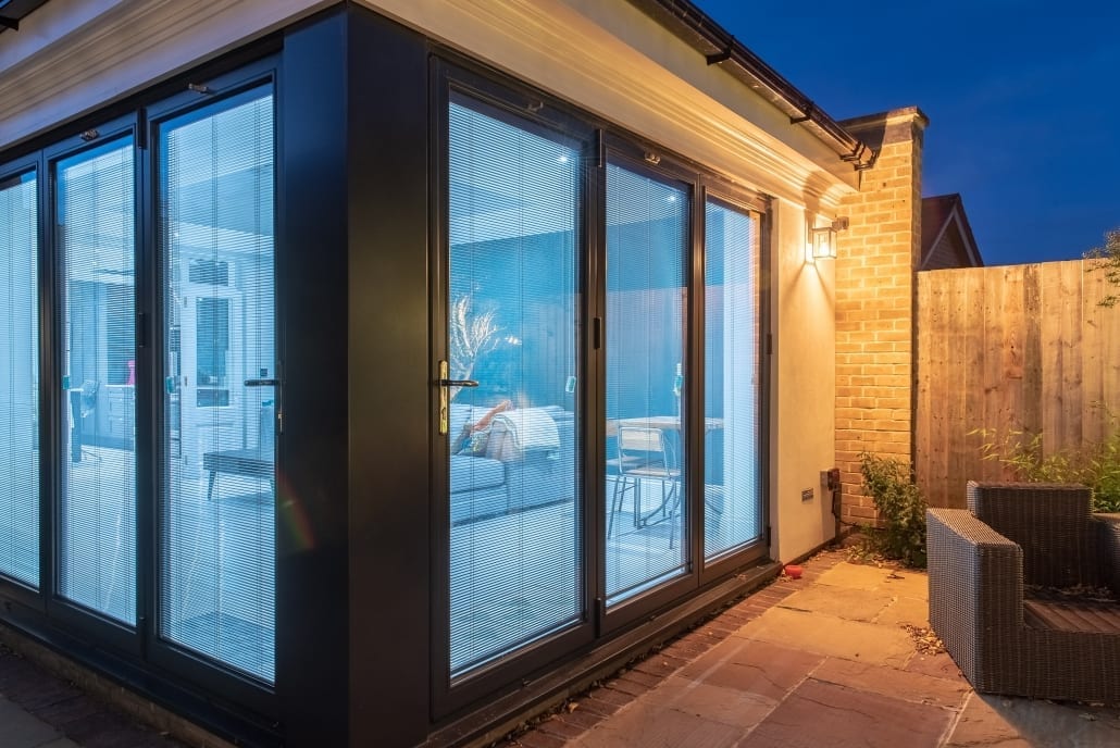 Lit interior visible through open bifold doors, Colchester project