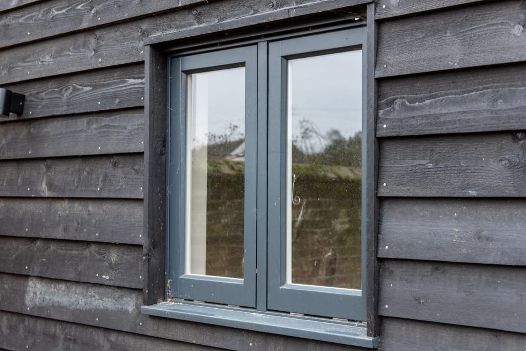 Floor-to-ceiling glazing flanking Bereco timber French doors on barn