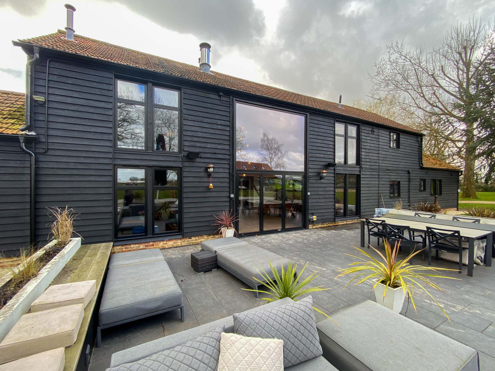 Large curtain wall screen with bifold doors on the rear elevation of Essex barn conversion