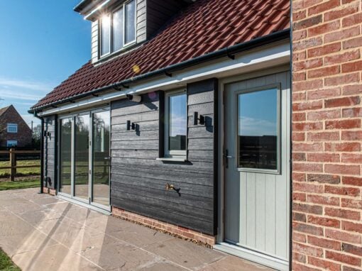 Rear elevation of Lawford new-build showing Smarts aluminium bifold doors in Agate Grey