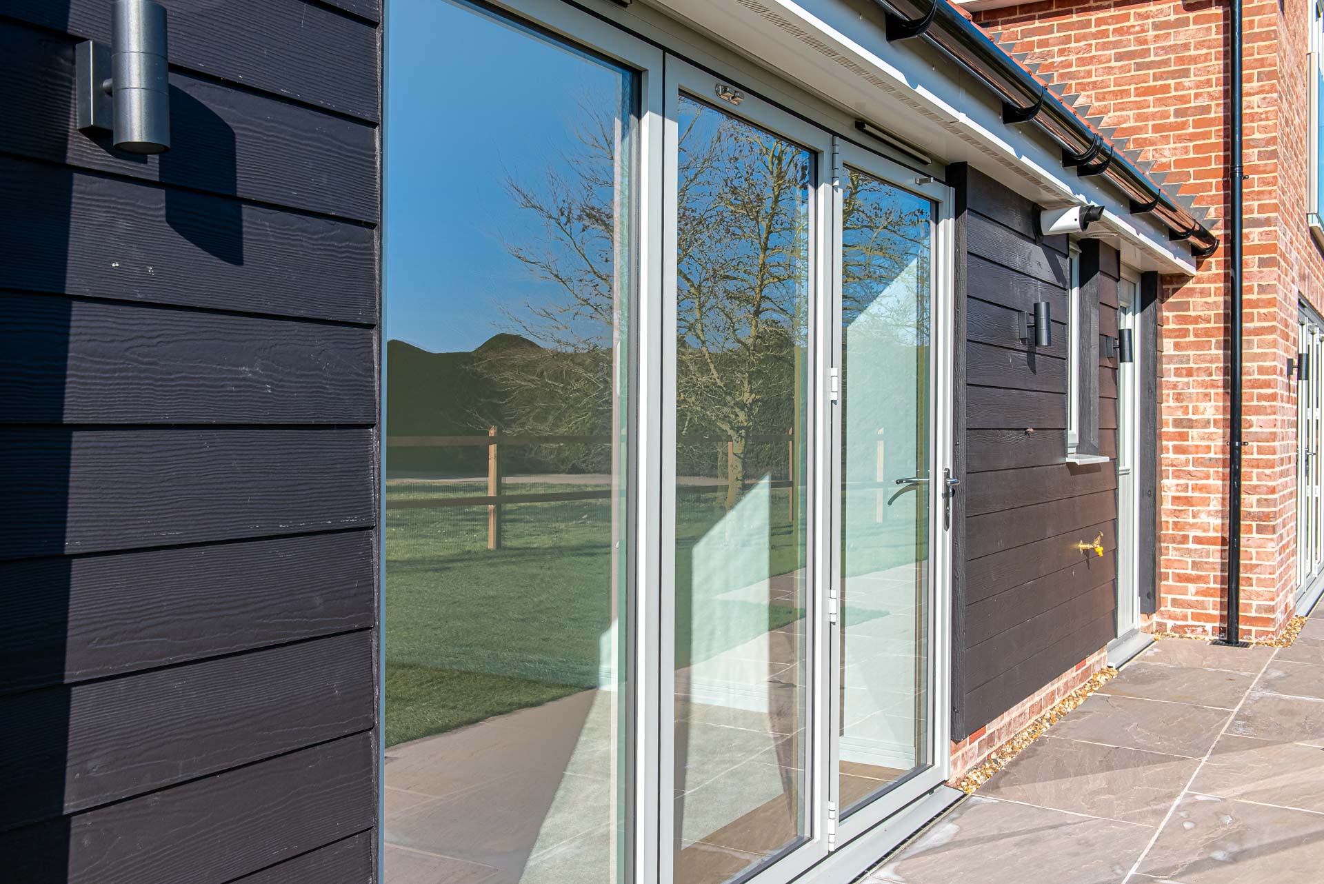 Smarts aluminium bifold doors open fully revealing garden views from kitchen-diner