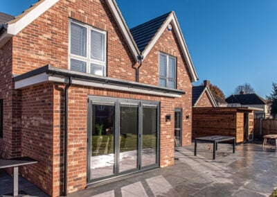 Red brick home with white casement windows and bifold doors, Essex