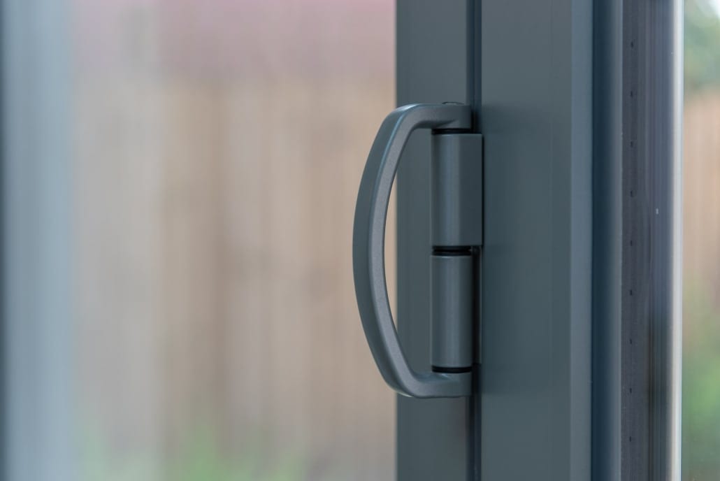 Origin three-leaf bifold doors in powder coated grey opening to garden