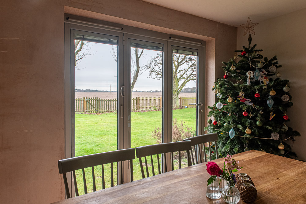 Origin slimline bi-fold doors open to garden, three-part unit with traffic door
