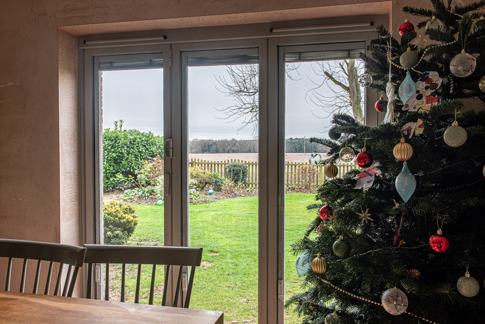 Interior view through Origin bi-fold doors to Suffolk countryside