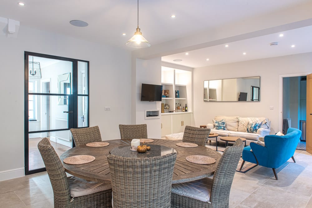 Interior view of glazed extension with bifold doors open to garden