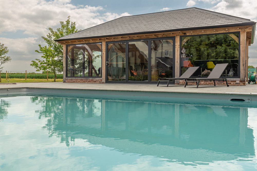 Interior view of pool house through open aluminium bifold doors