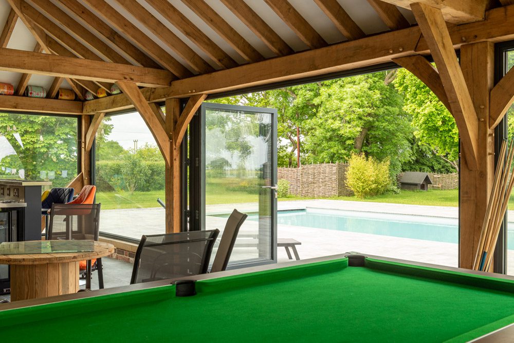 Smarts aluminium bifold doors open to pool house terrace