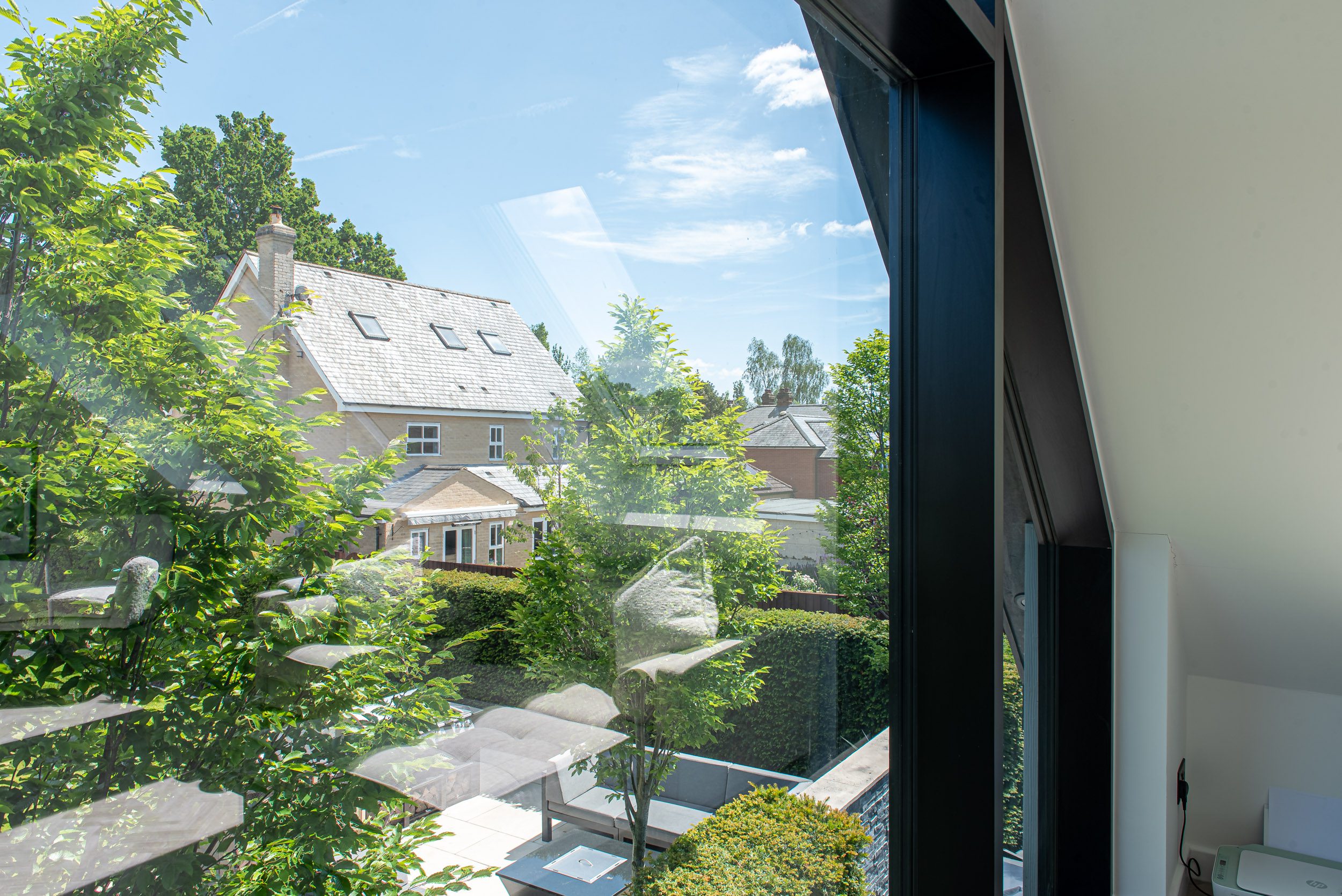 Interior view of home office with commercial aluminium gable glazing framing garden views