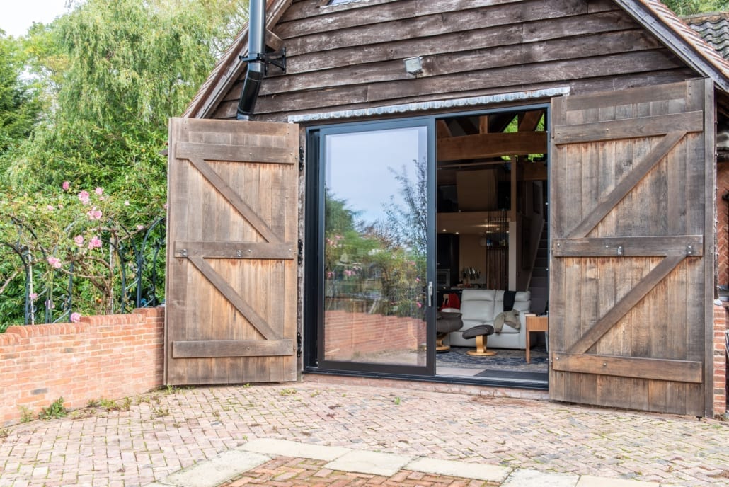 Barn conversion interior with open-plan layout and full-height aïr glazed doors