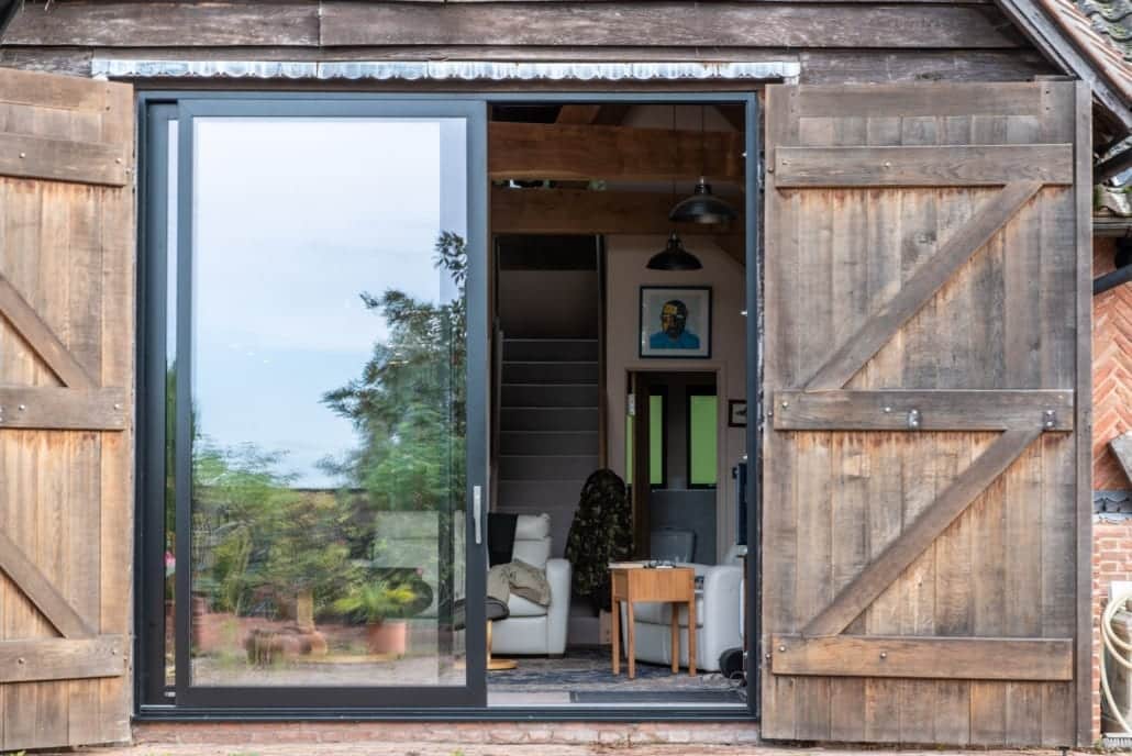 Dark aluminium windows in timber gable, varied aperture sizes reflecting building geometry