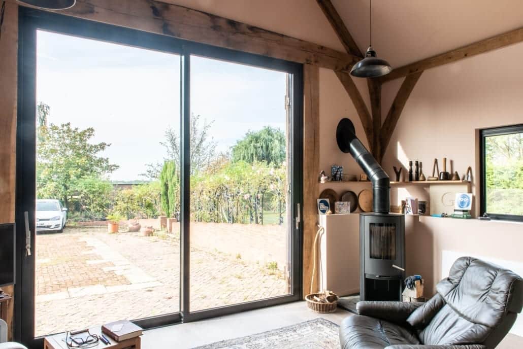 Green oak gable with minimal aluminium window glazing, barn conversion
