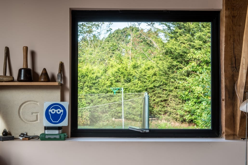 Smarts Heritage aluminium windows in dark finish set into green oak gable of barn conversion