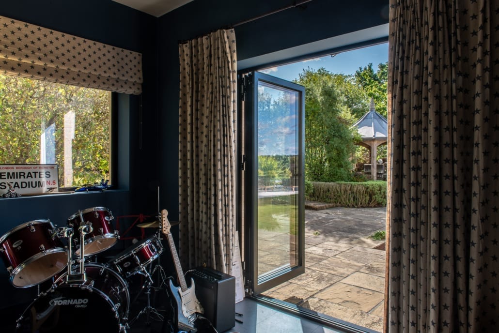 Interior of the music and games room with aïr bifolds open to outside