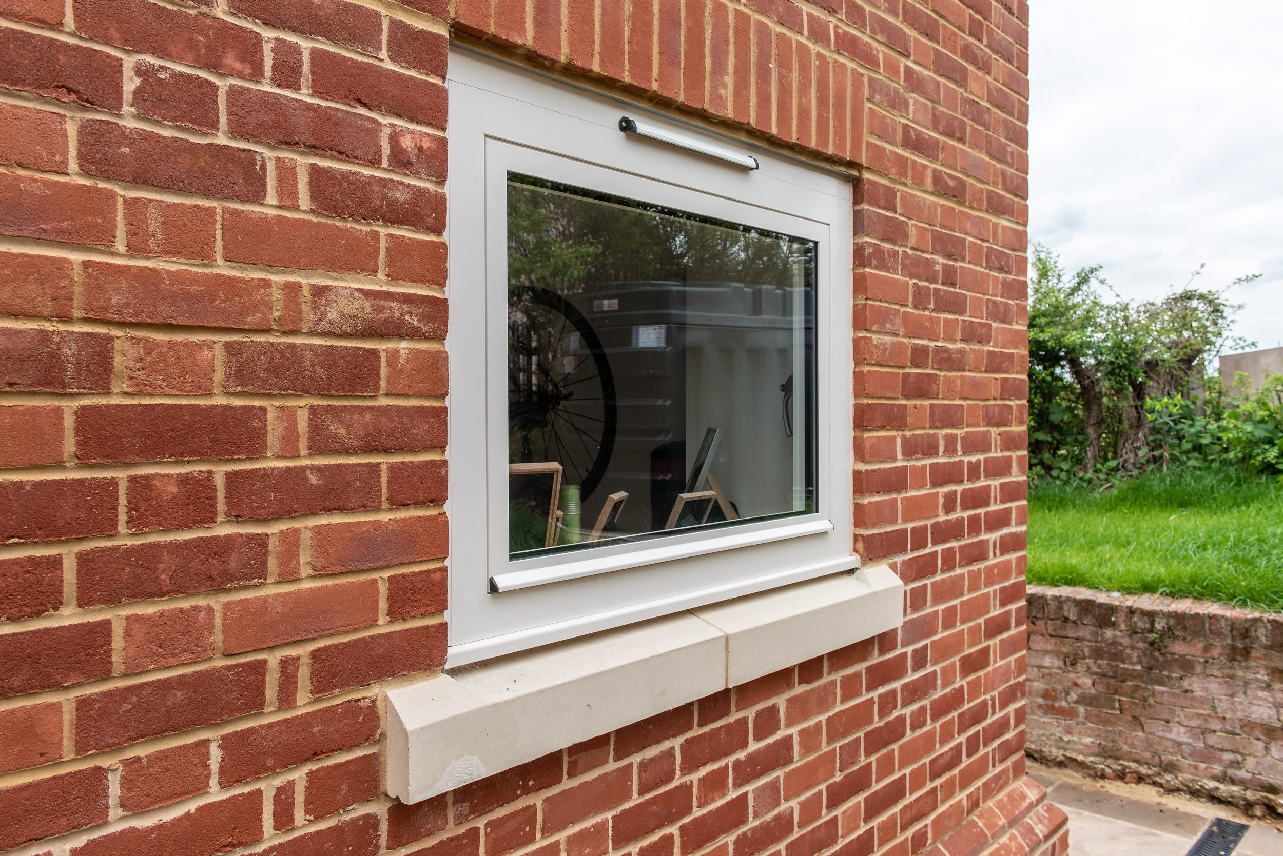 Poolside view through Smarts aluminium bifold doors in cream finish