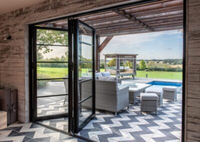 Dark glazed aïr bifold doors on a scorched timber clad pool house