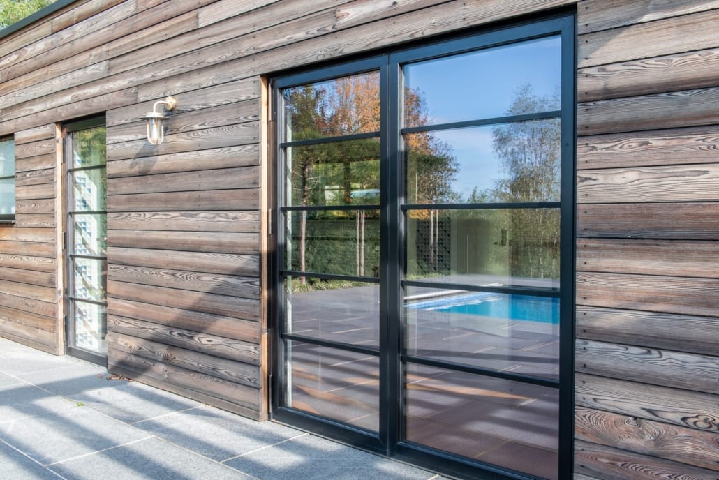 Exterior view of pool house with geometric tiles and valley backdrop