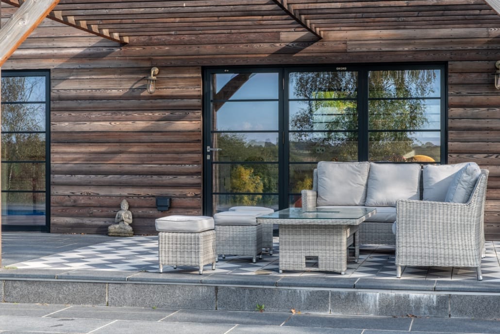 Pool house exterior with scorched timber cladding and dark aluminium glazing