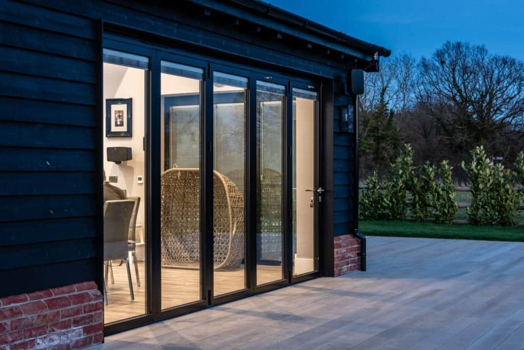 Smarts bifold doors and full-height glazing on Essex barn at night