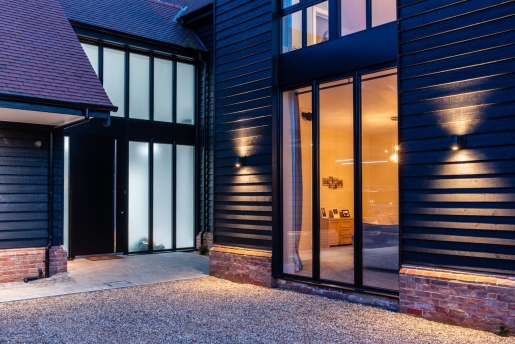 Exterior view of barn with Smarts bifolds and aïr bifolds at night